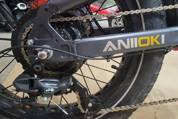 An e-bike chain running through a Shimano Tourney derailleur on an Aniioki fat tire electric bike