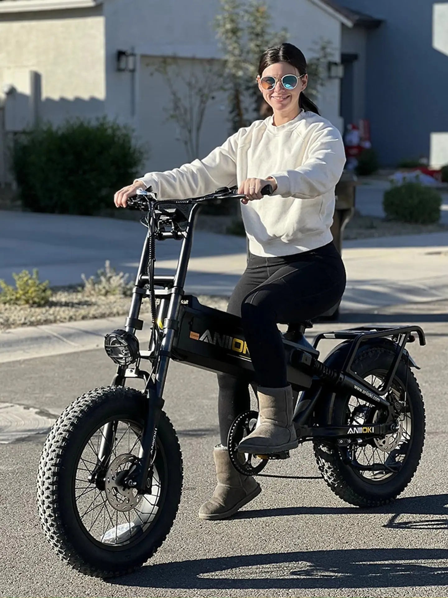 A Caucasian woman commuting on the Aniioki A8 Pro Max 52V 70Ah, an ebike with 200 mile range designed for long distance travel without frequent charging.